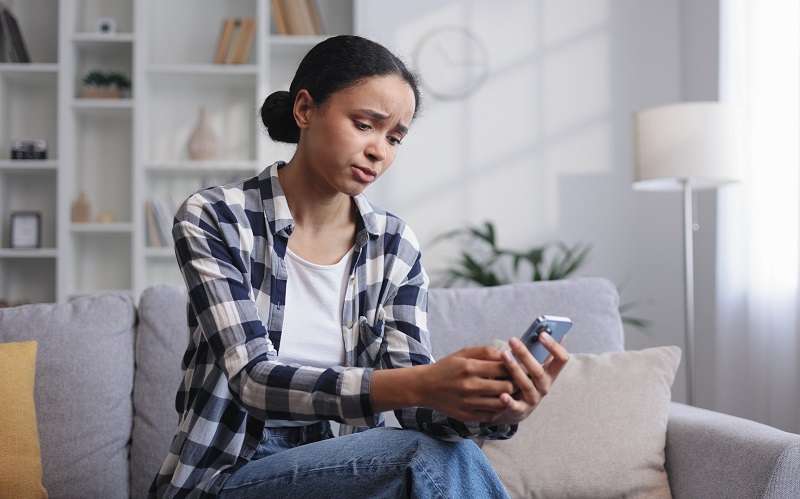 Women holding phone with frustrated face